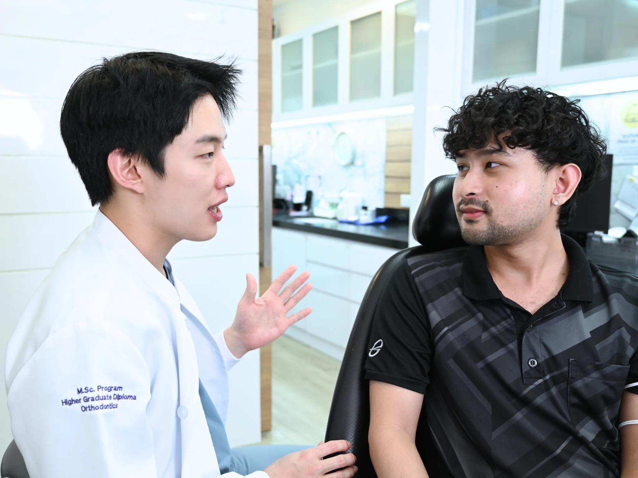 ทพ.ชยุต จิระวิชิตชัย อธิบายแผนการรักษาให้คนไข้ข้างเก้าอี้ทำฟัน