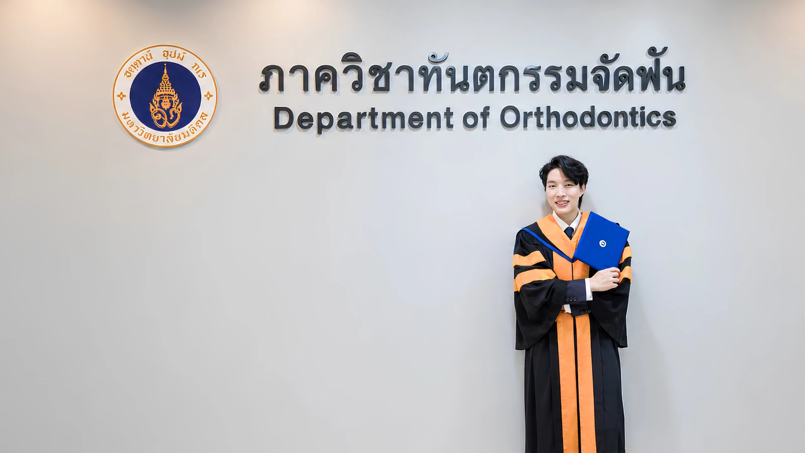 ทพ.ชยุต จิระวิชิตชัย ในชุดครุยหน้าภาควิชาทันตกรรมจัดฟัน มหาวิทยาลัยมหิดล
